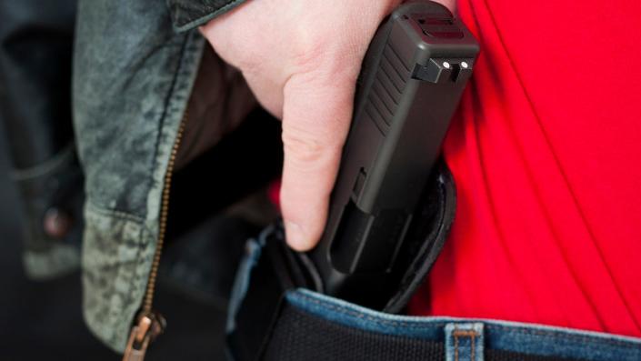 Man with hand on his firearm