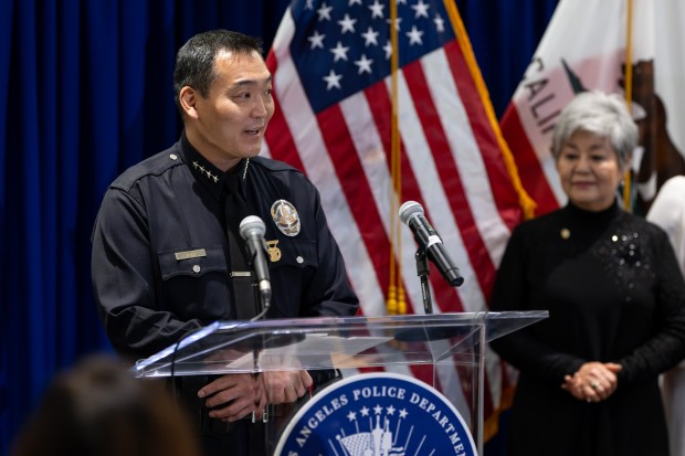 Dominic Choi speaks to the crowd with his mother Jin...