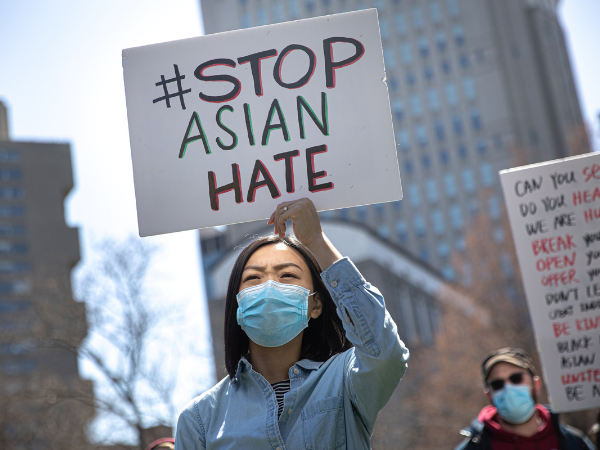 Asian woman raises "Stop Asian Hate" sign