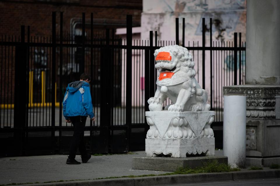 Lion statues of Vancouver’s Chinatown Millennium Gate covered in orange tape after being defaced for the second time in the matter of weeks on Friday, May 29, 2020. (Maggie MacPherson/CBC)